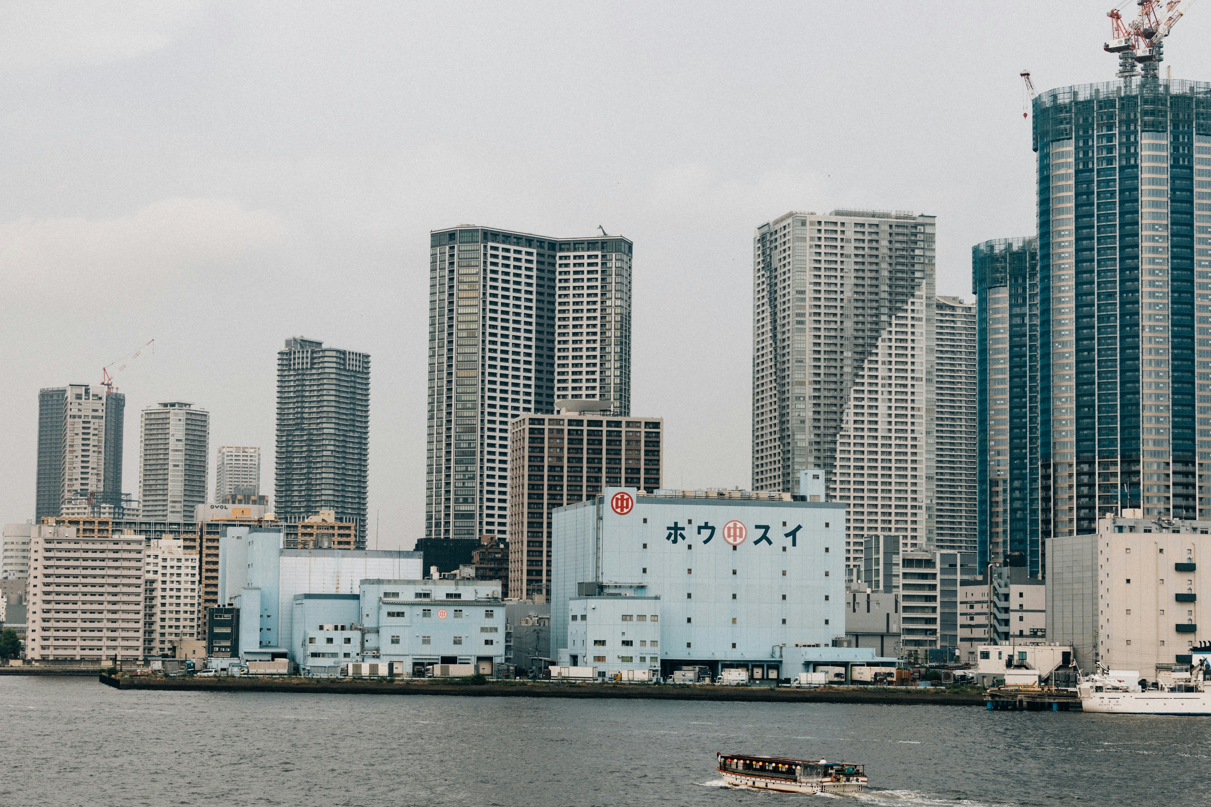 Modern city skyline with a river in the foreground.