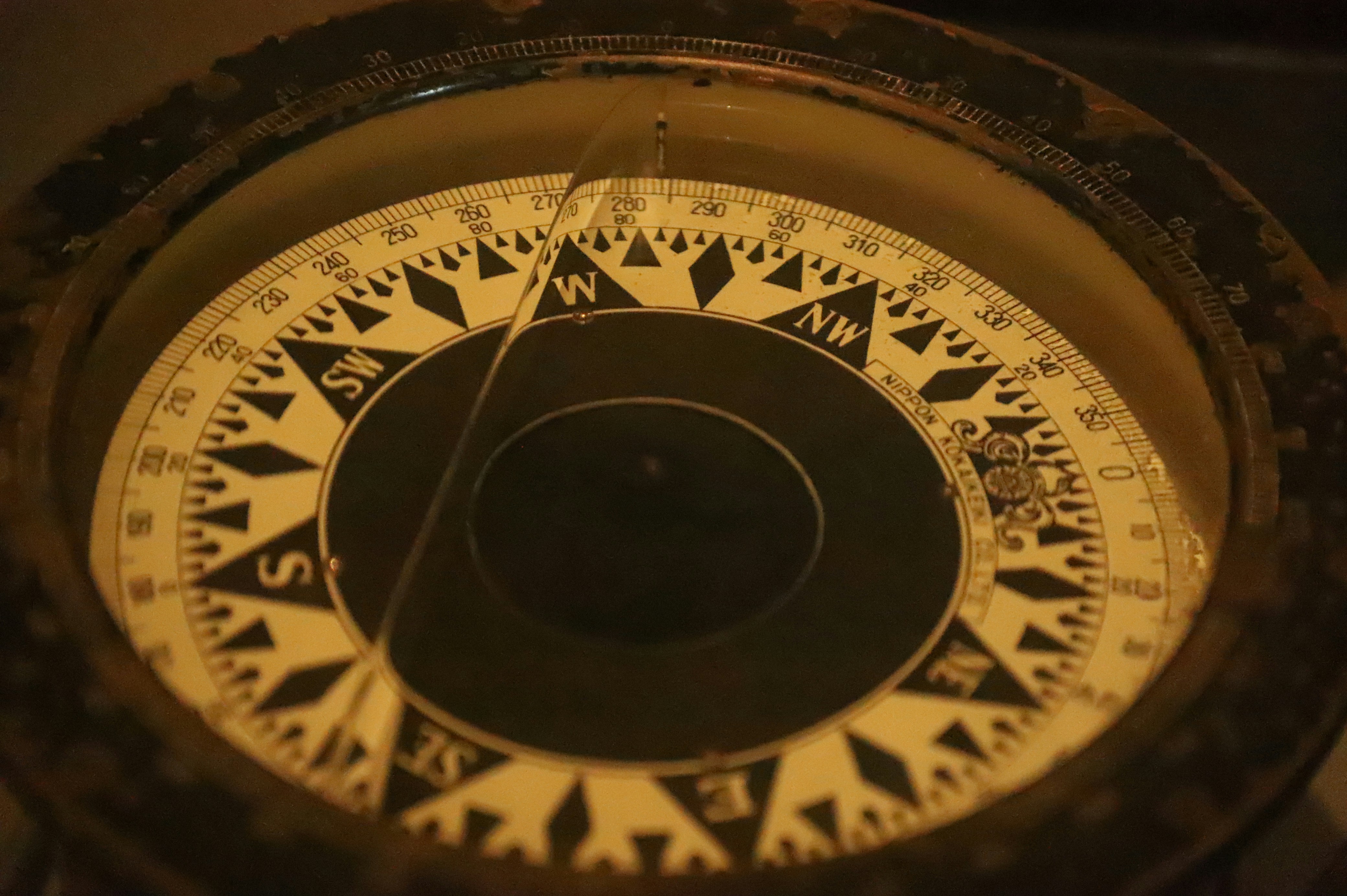 Primo piano di un quadrante di bussola antico che mostra le direzioni.
