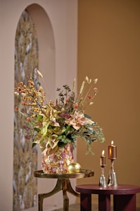 A floral arrangement with candles and decorative objects.