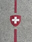 Swiss flag shield painted on concrete with red lines