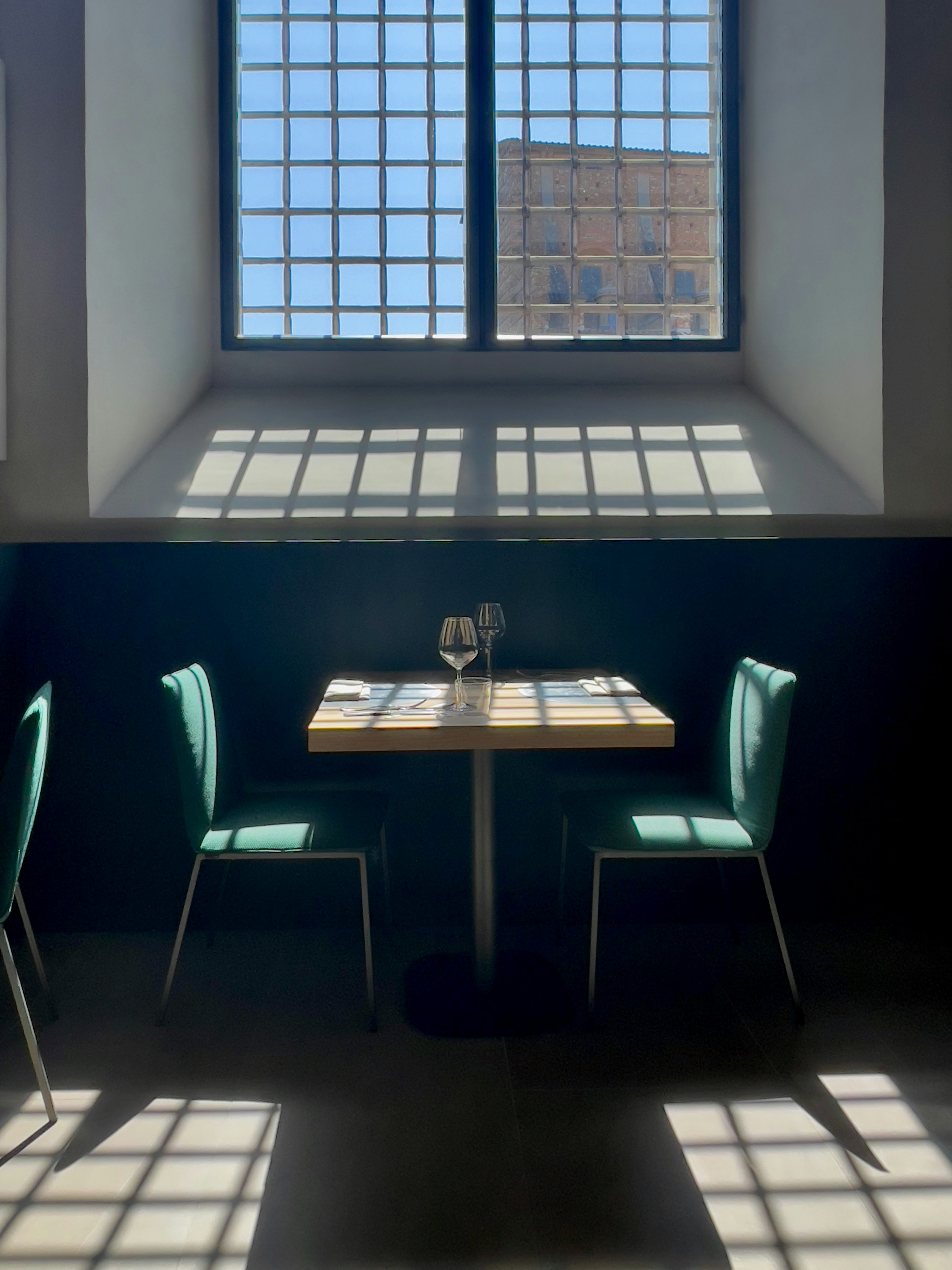 Tisch mit Stühlen am Fenster mit Sonnenlichtmustern