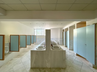Row of sinks and stalls in a public restroom.