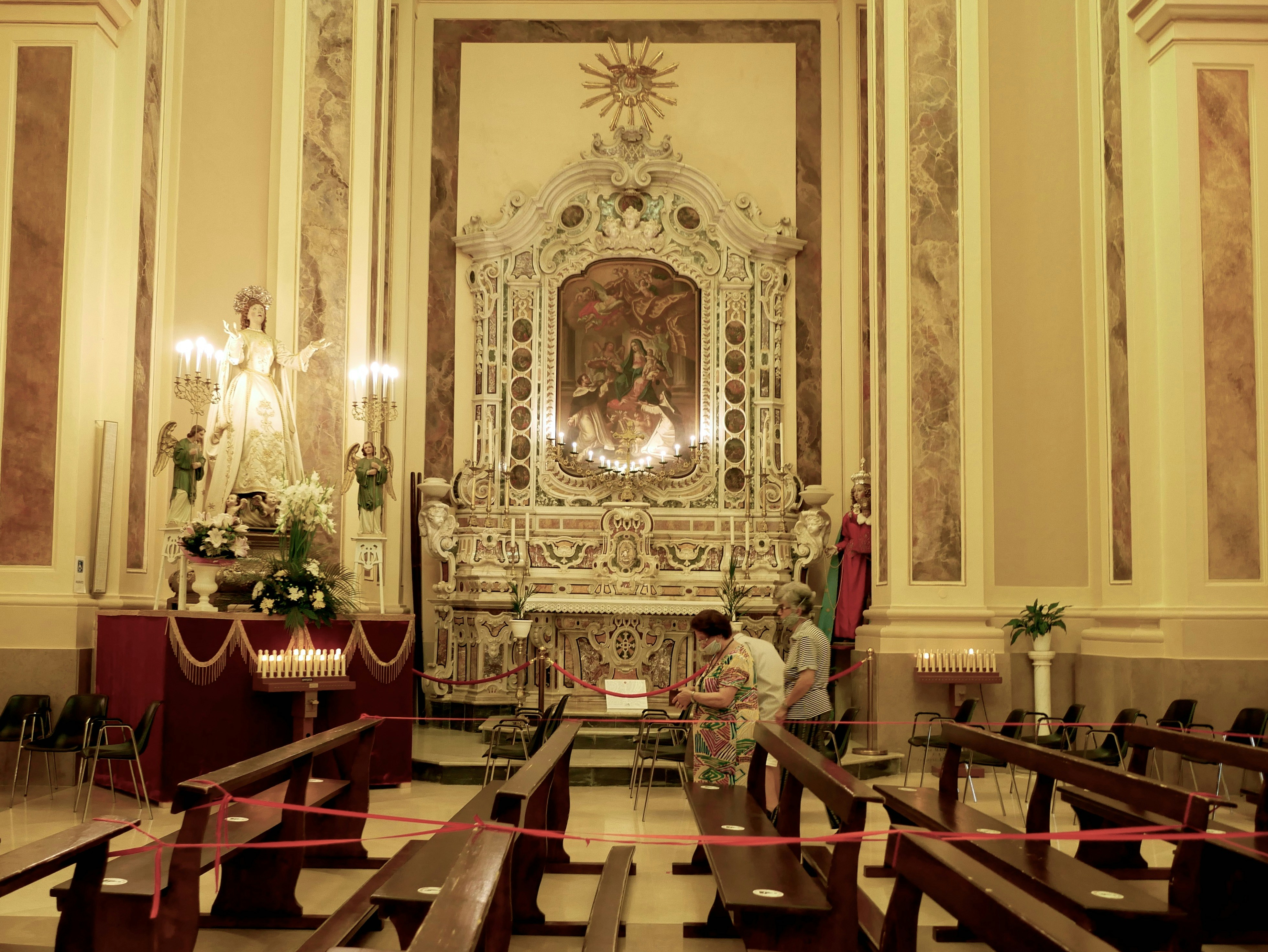 Interior de una iglesia con altar y bancos ornamentados.