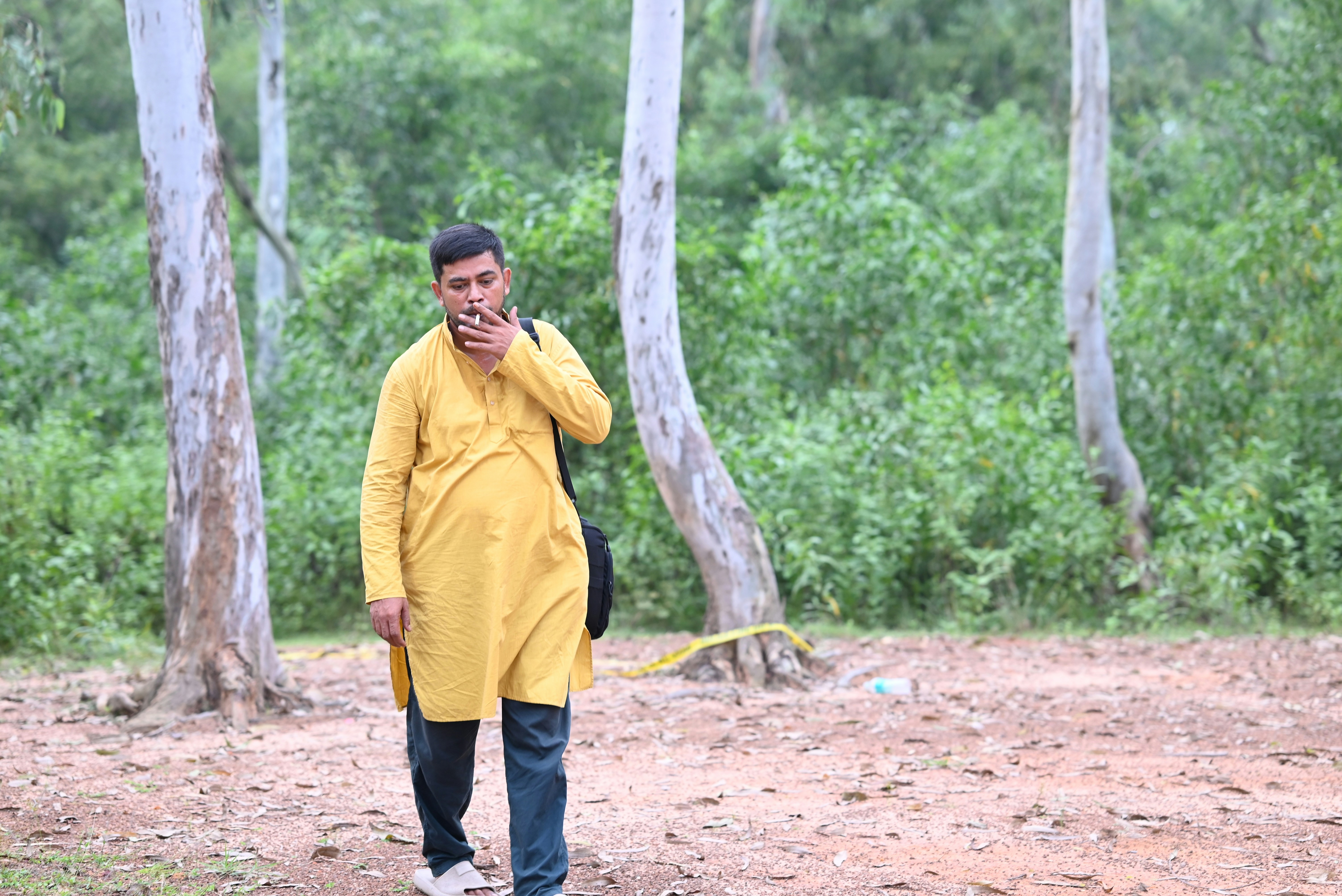 Man in yellow kurta walking in a forest