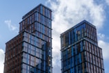 Two modern skyscrapers against a cloudy sky