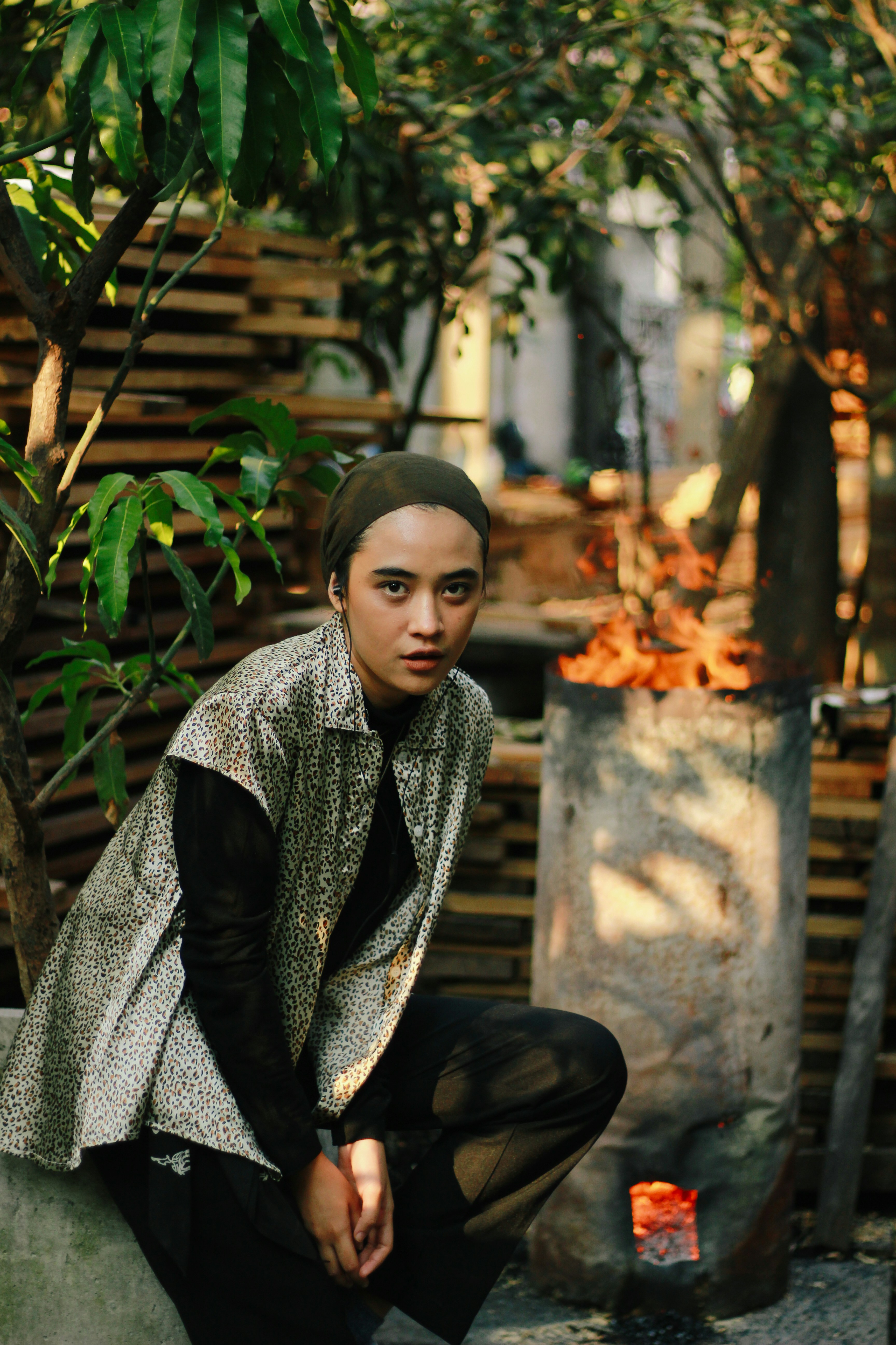 Woman in headscarf near outdoor fire pit
