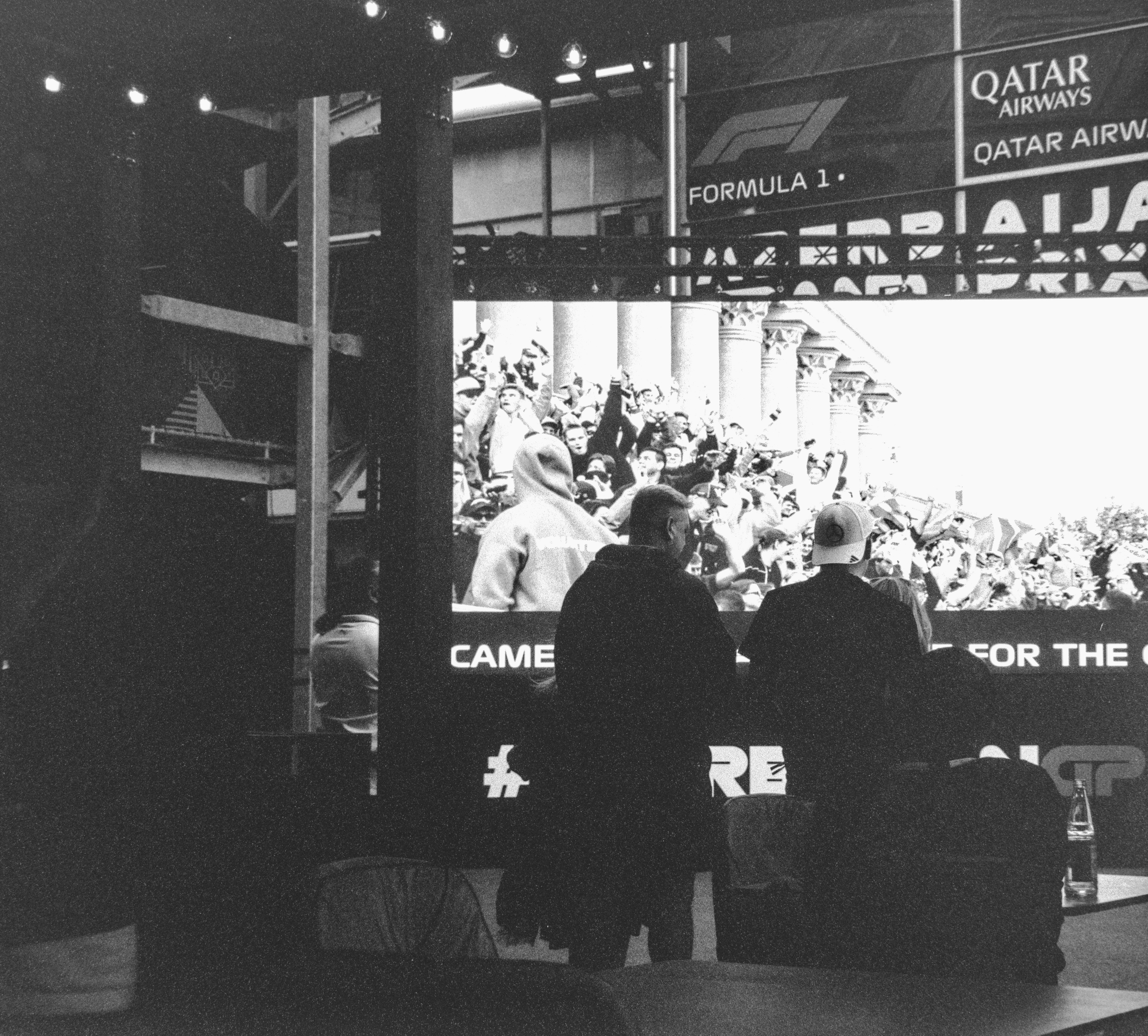 A diverse group of people discussing animatedly in front of a news screen, symbolizing public discourse and varied opinions on a controversial topic.