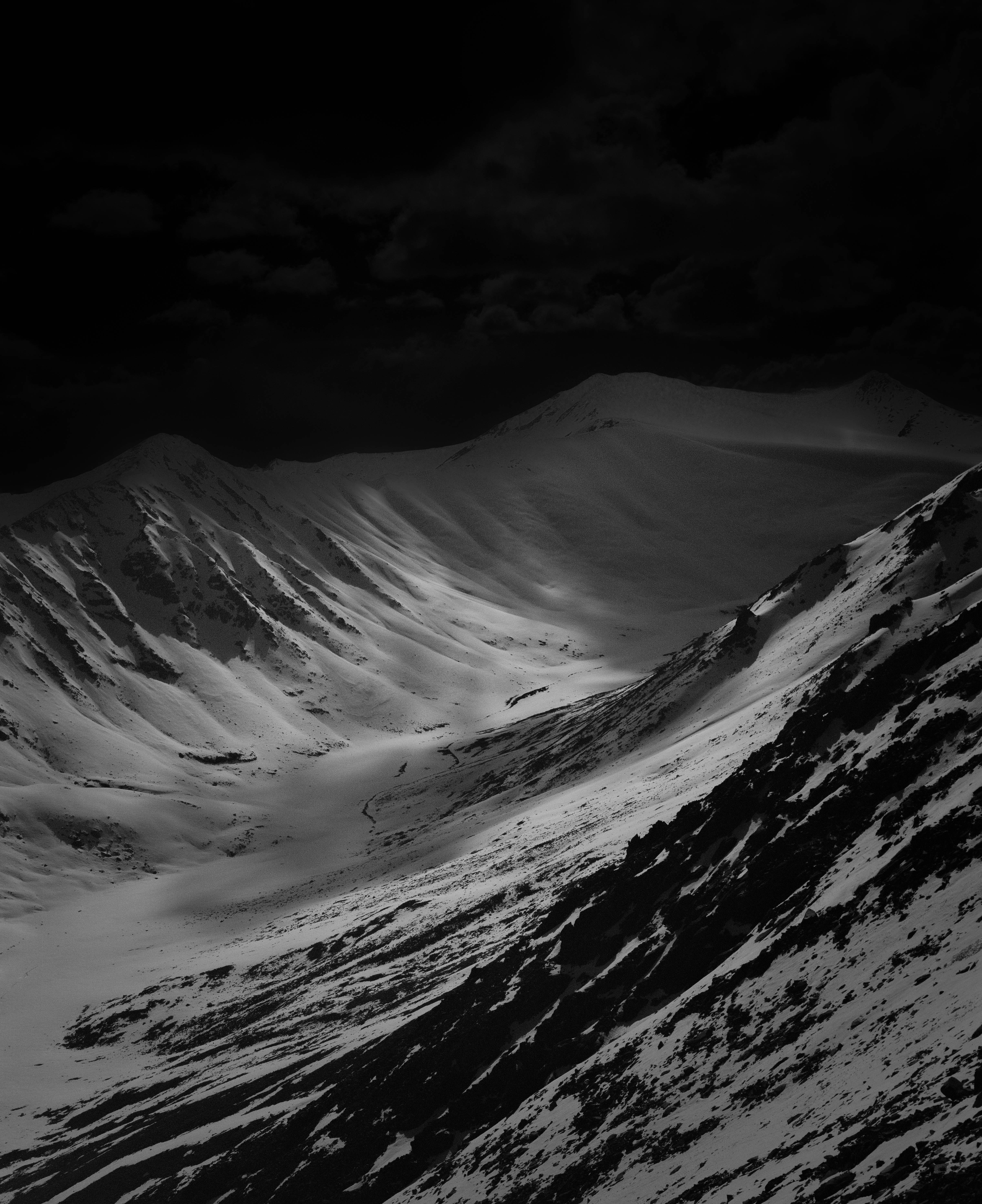 Snowy mountain range under a dark sky