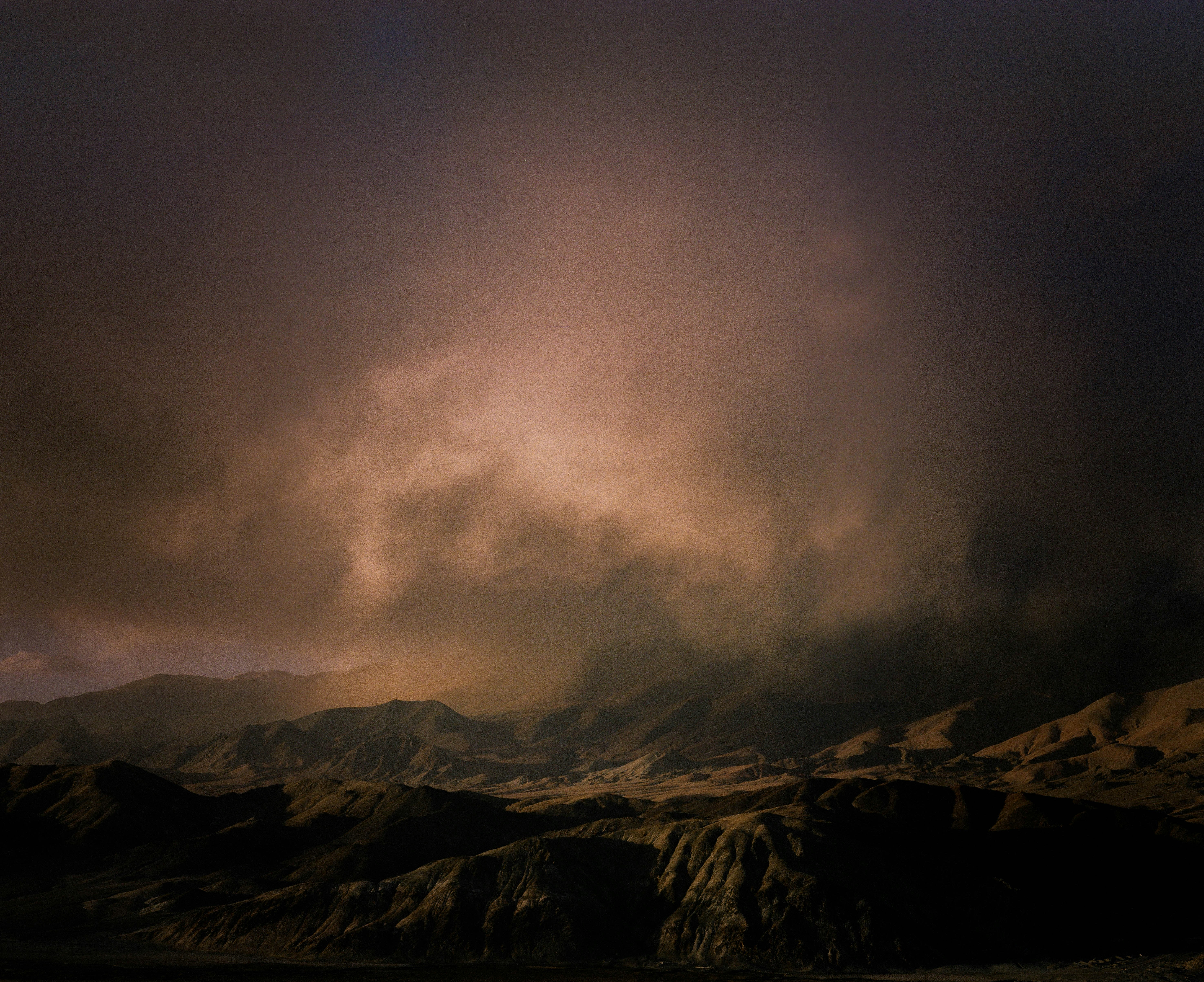 Rocky terrain under dramatic, cloudy skies