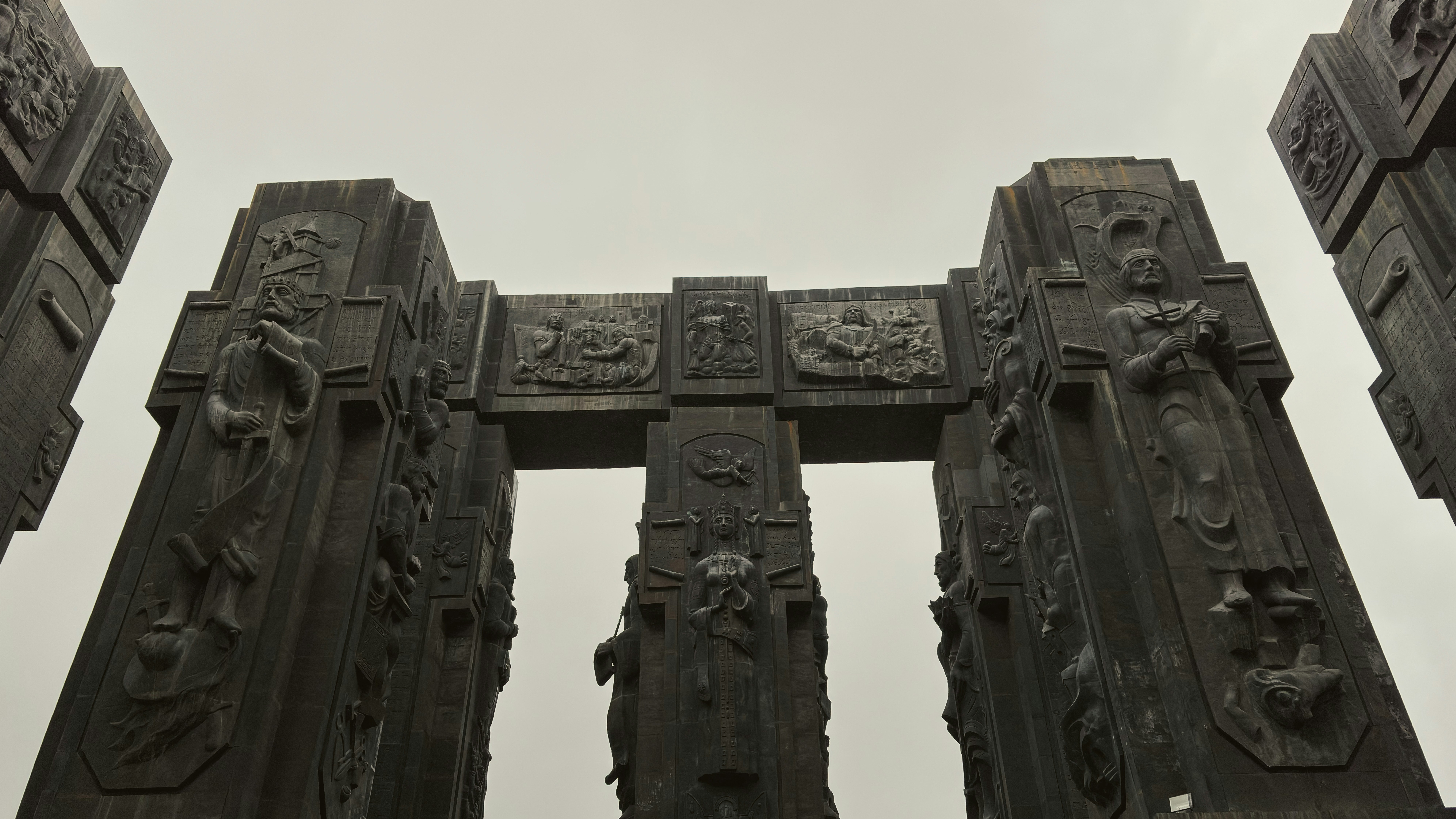Monumento con pilastri e sculture in rilievo sotto il cielo nuvoloso