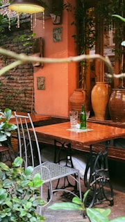 Outdoor cafe table with chairs and decorative vases.