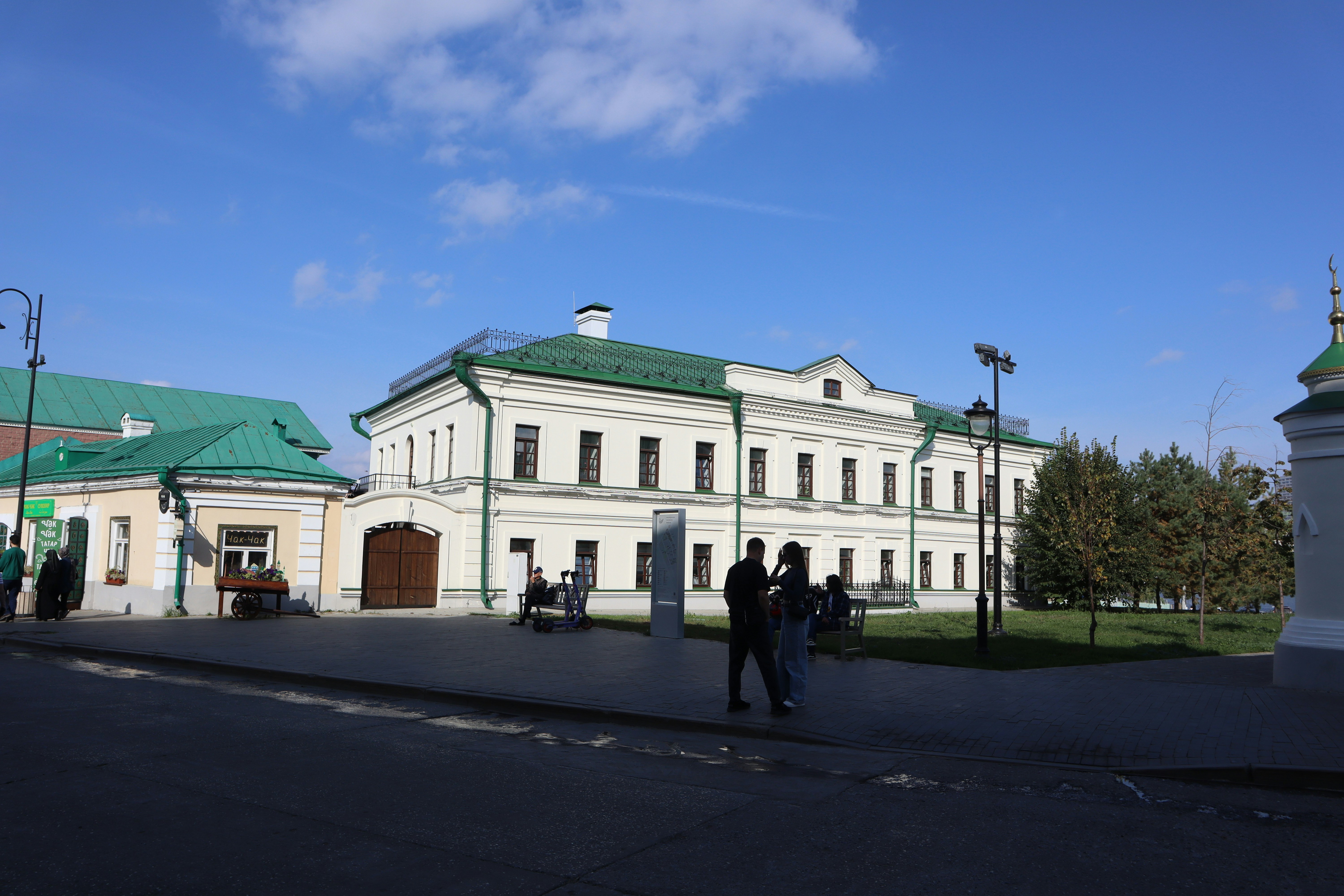 White building with green roof under blue sky.