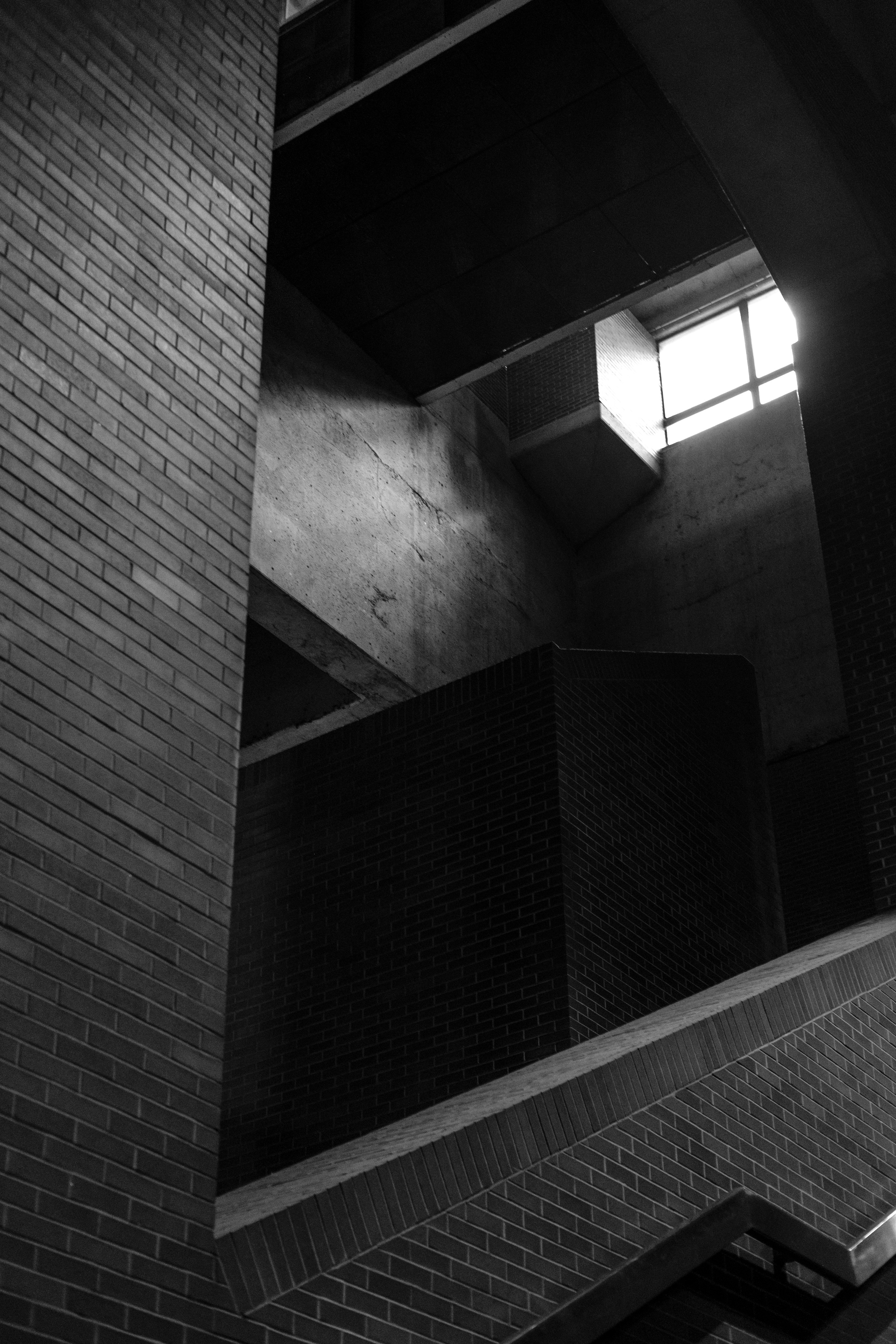 Geometric shadows in a brutalist brick building interior