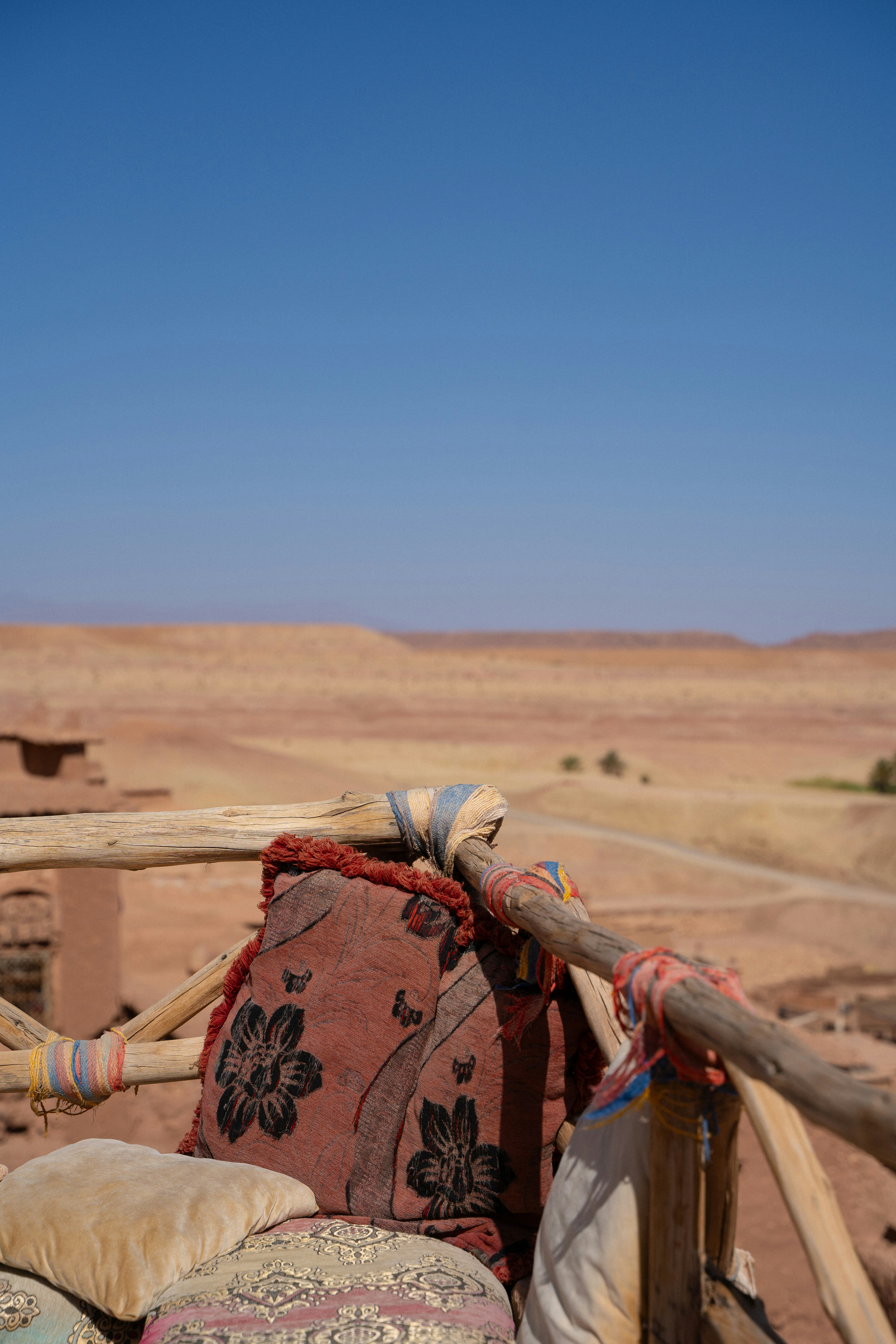 Decorative cushions on a wooden railing overlooking desert landscape