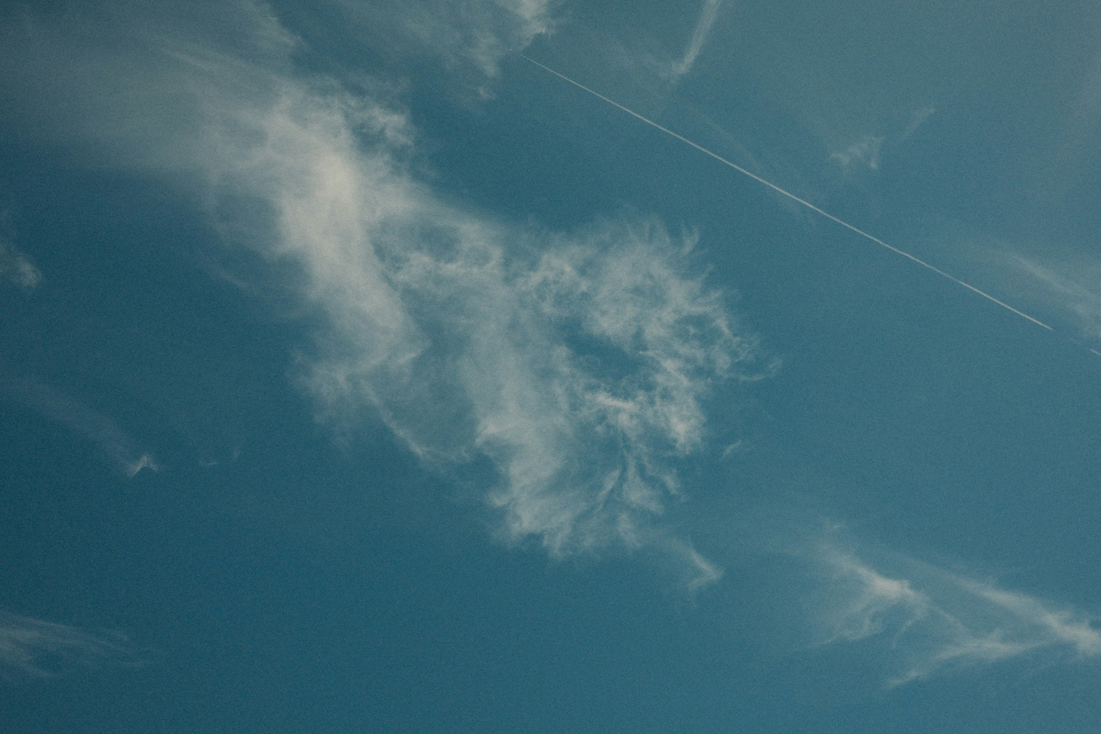 Wispy clouds drift across a clear blue sky.
