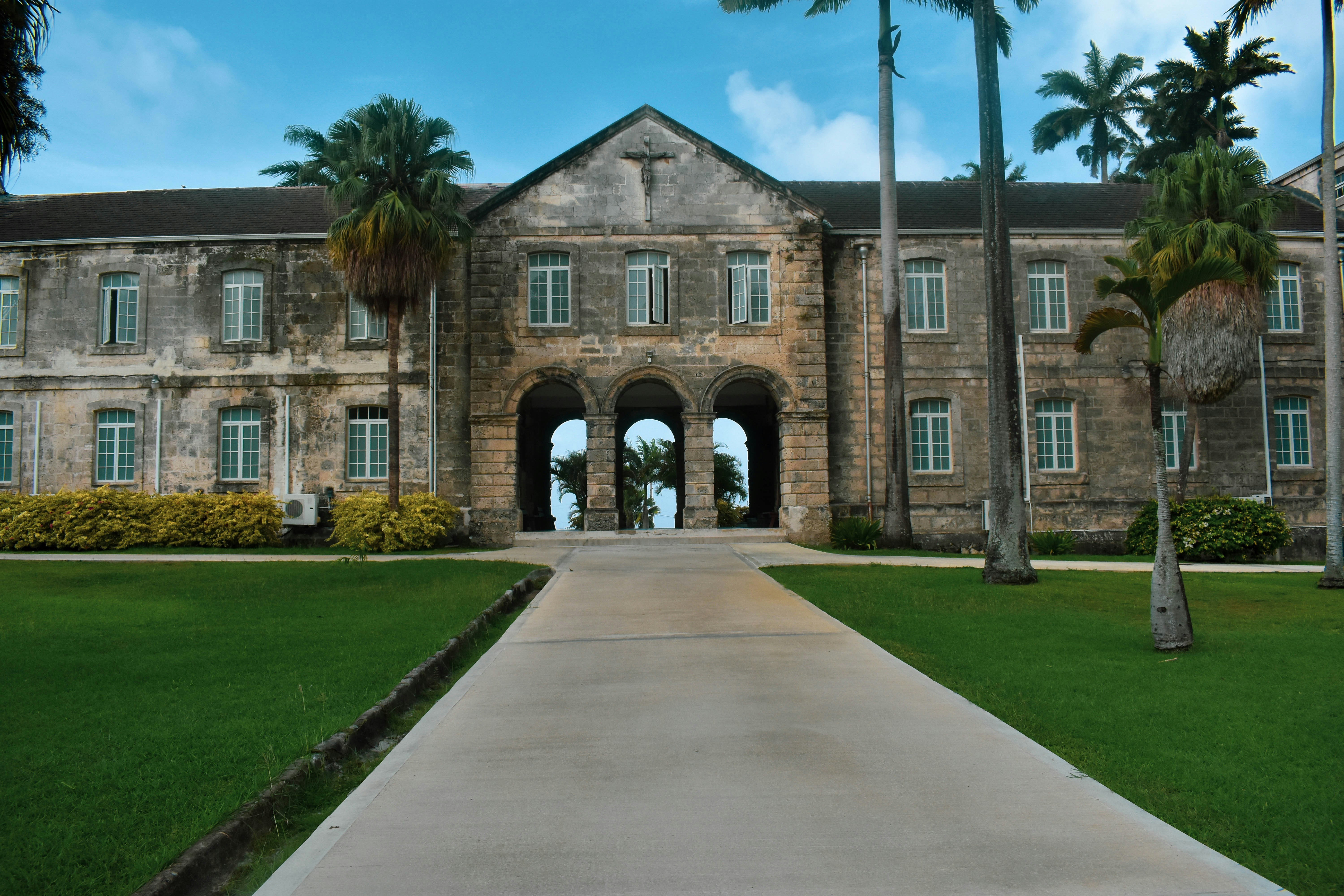 Codrington College in Barbados, photographed head-on with a clear blue sky and an open view through the central arch.