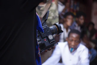 Filming event with professional video camera and crowd.
