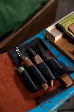 Four carving knives with wooden handles and black sheaths
