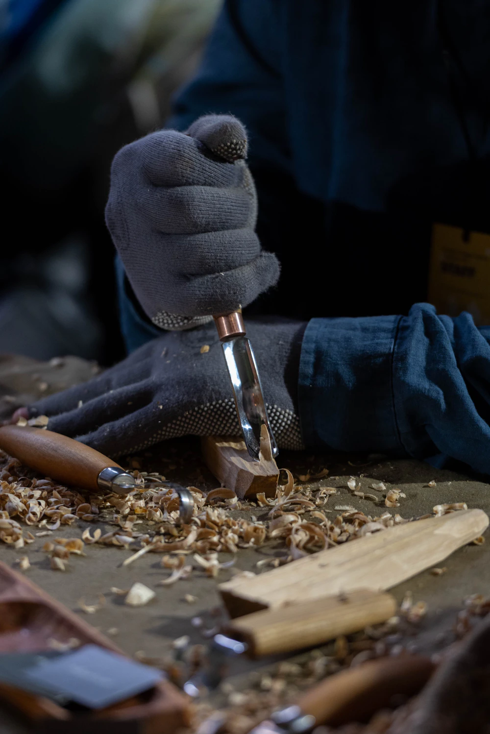 Hands shaping timber with chisels, the hand finishing on custom furniture