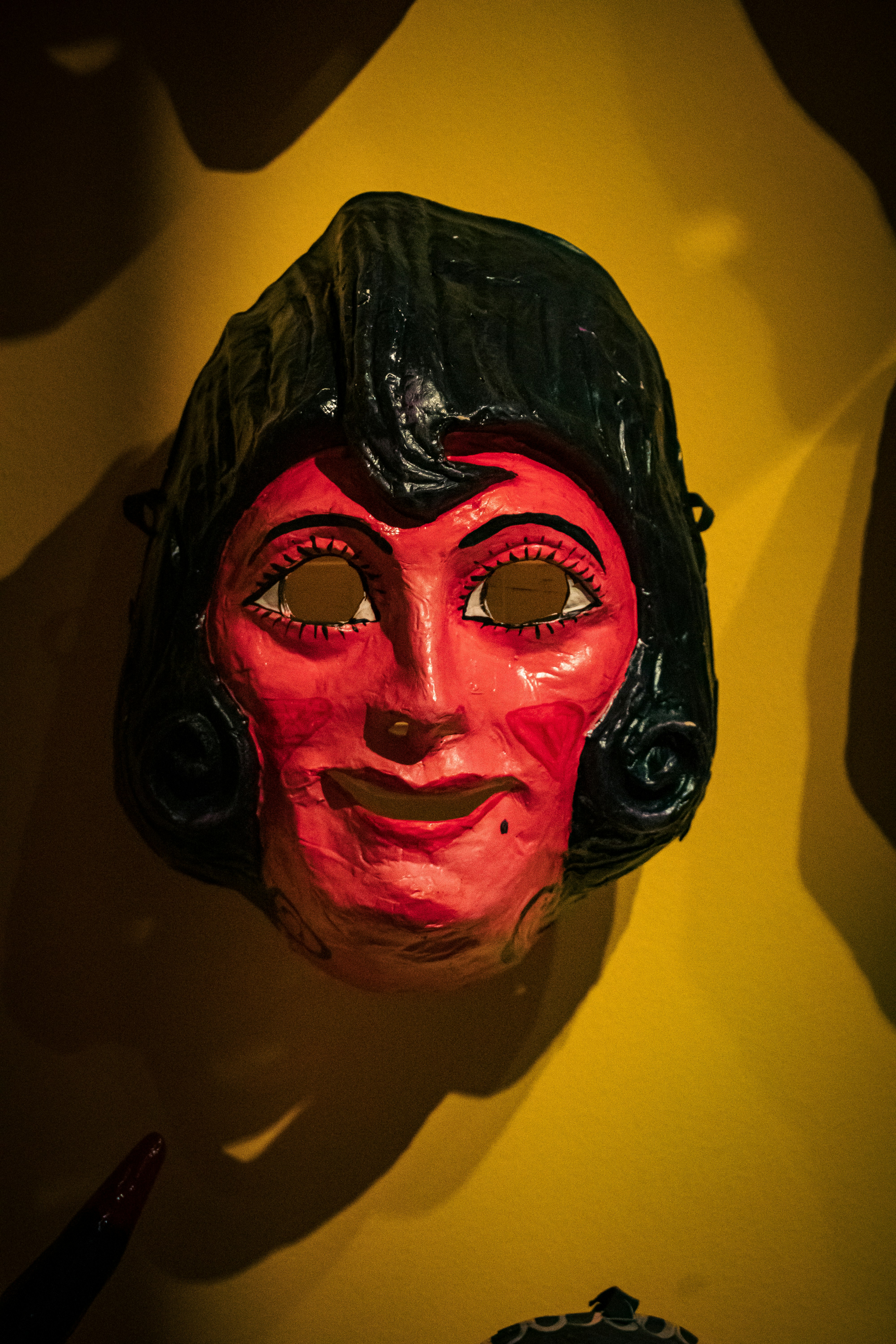 A red mask with black hair and painted eyes.