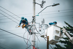 Linemen working on a utility pole with bucket truck.