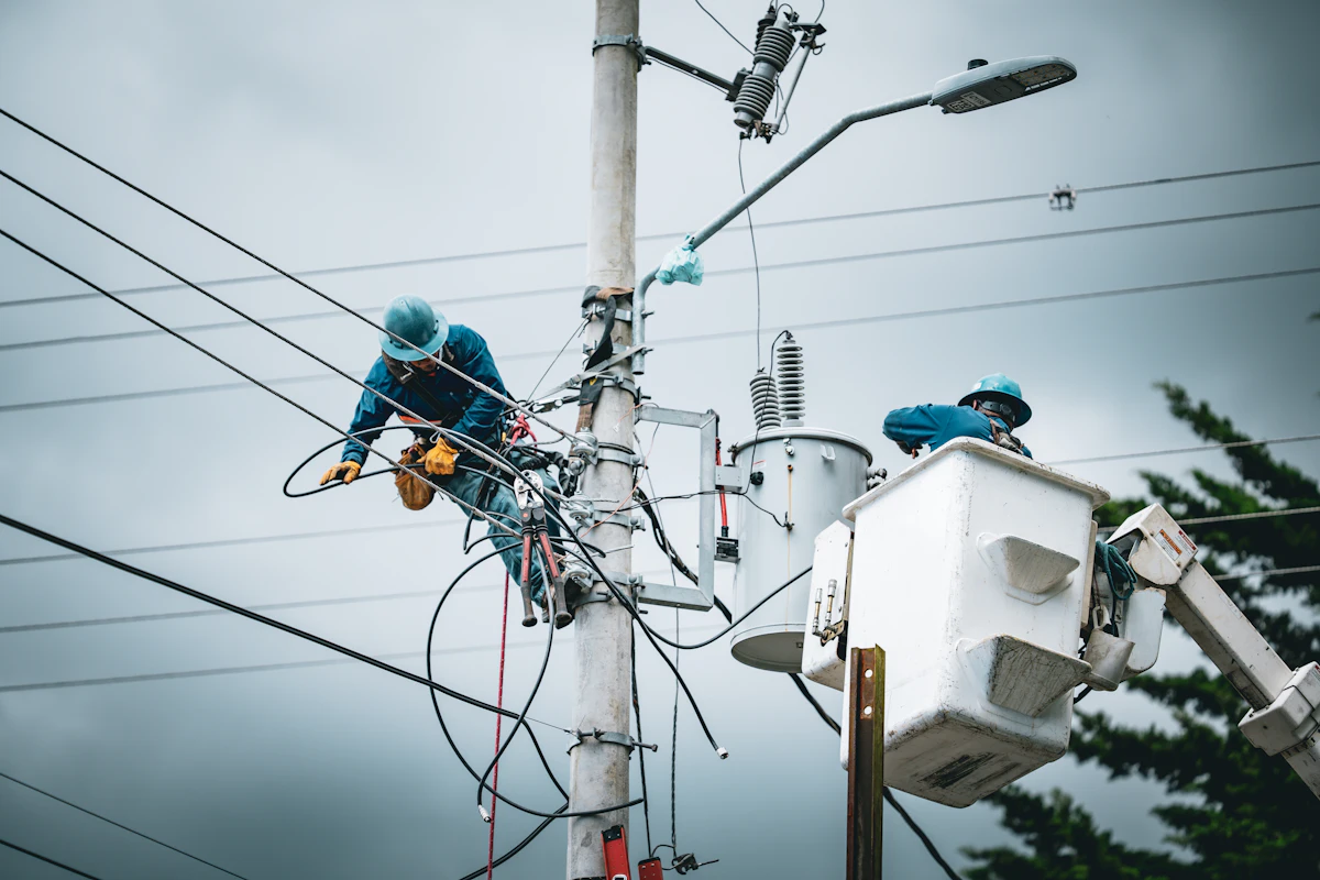 Line crew working from bucket trucks on a utility pole