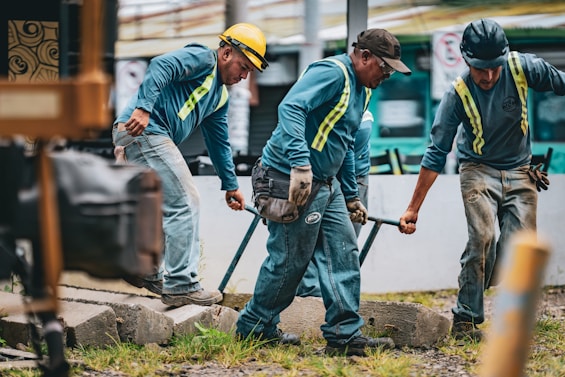 Construction workers laying down railroad tracks together.