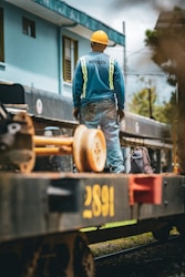 Construction worker standing on train car