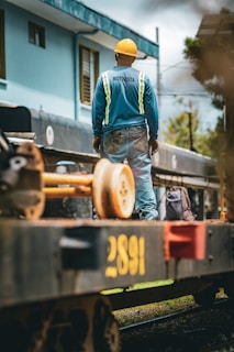 Construction worker standing on train car