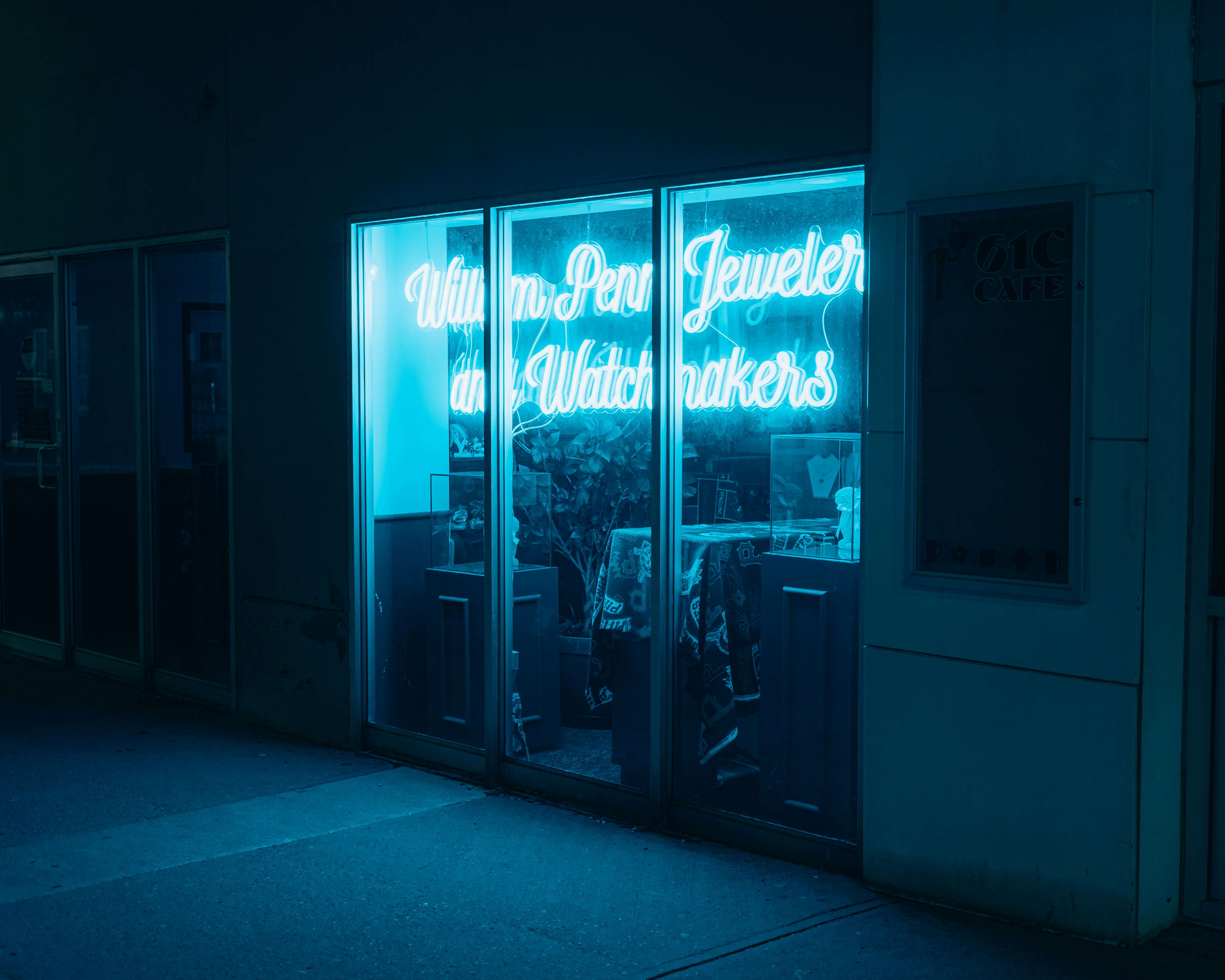 Neon sign glows blue in a jewelry store window