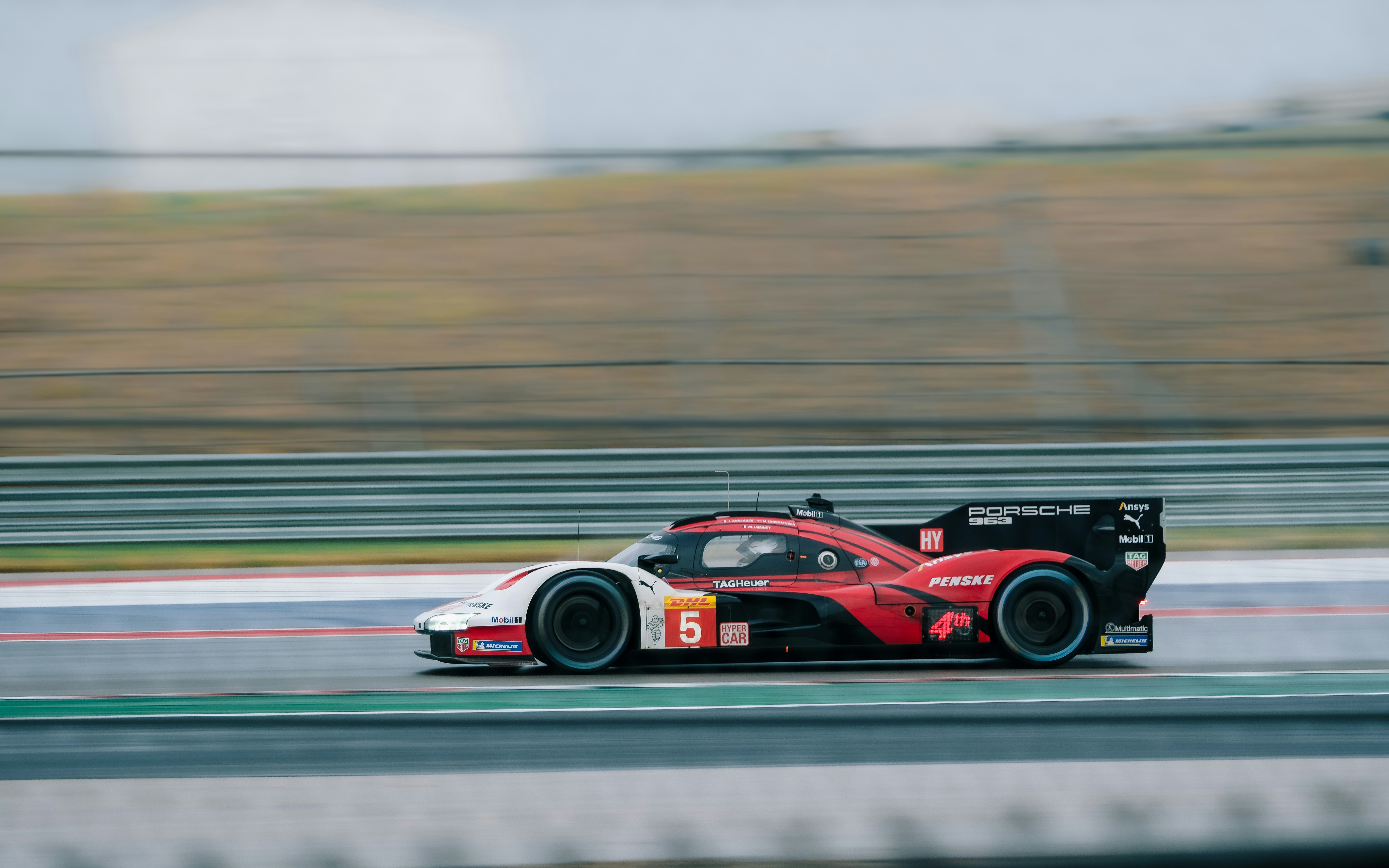 Red and white race car speeding on track