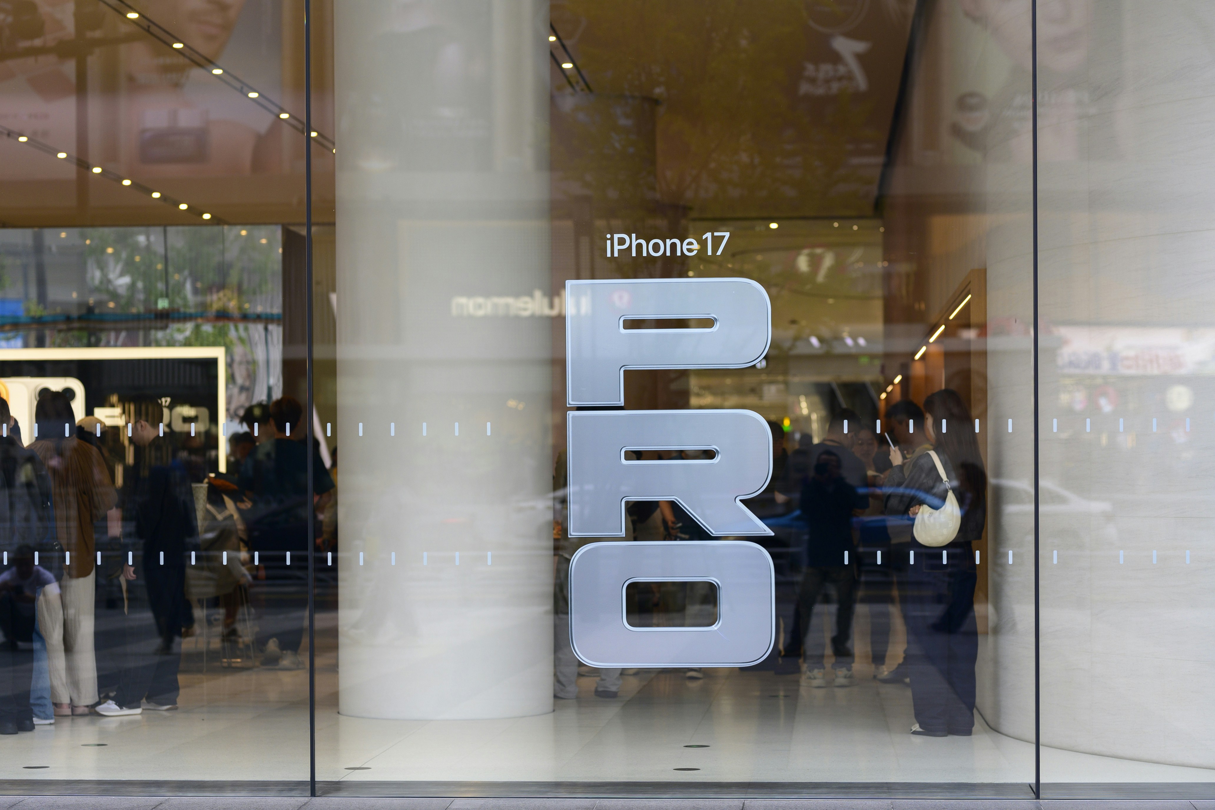 Grande enseigne pro sur la vitrine d’un magasin avec l’iPhone 17.