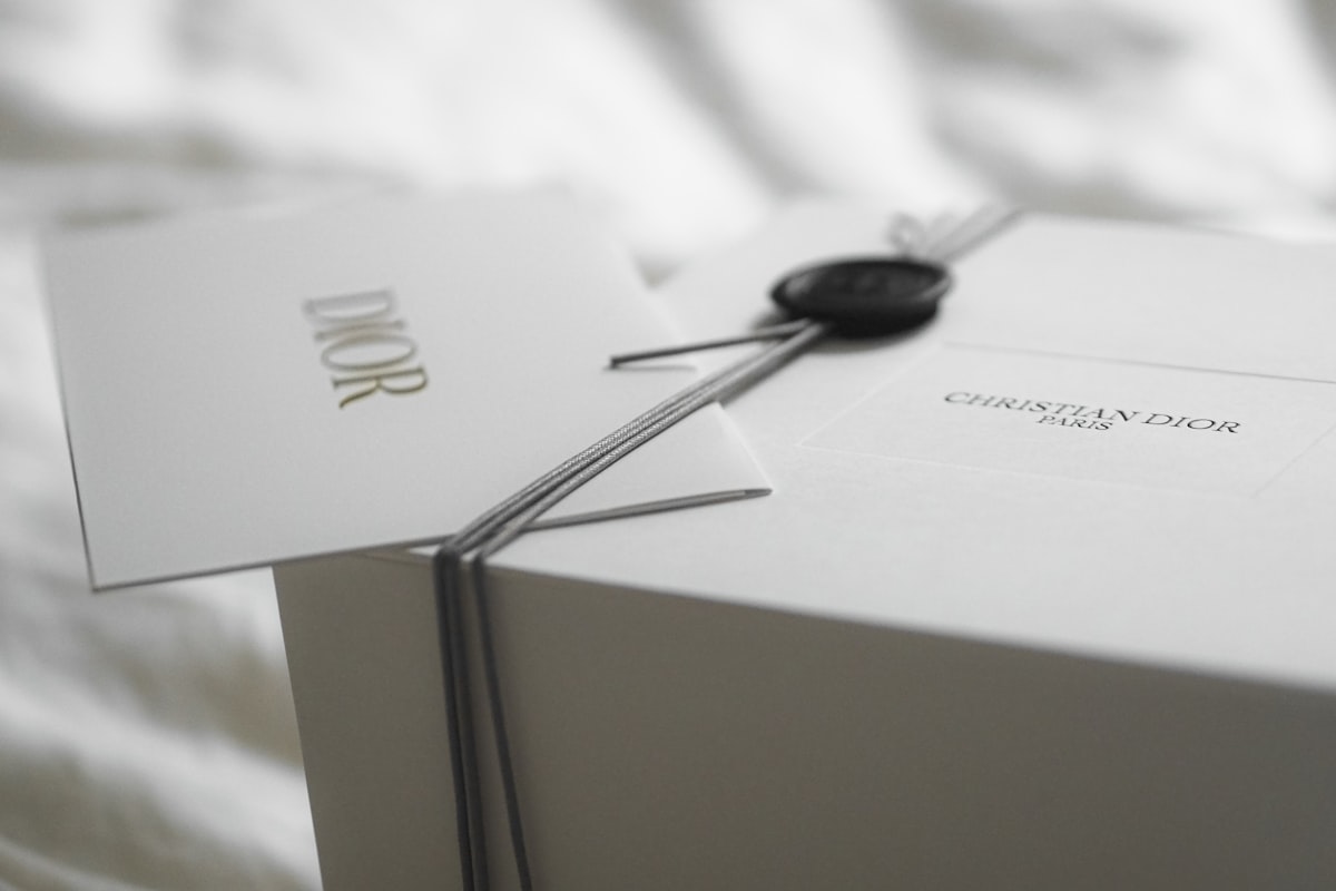 Dior luxury gift box with ribbon and tag representing premium brand packaging across industries