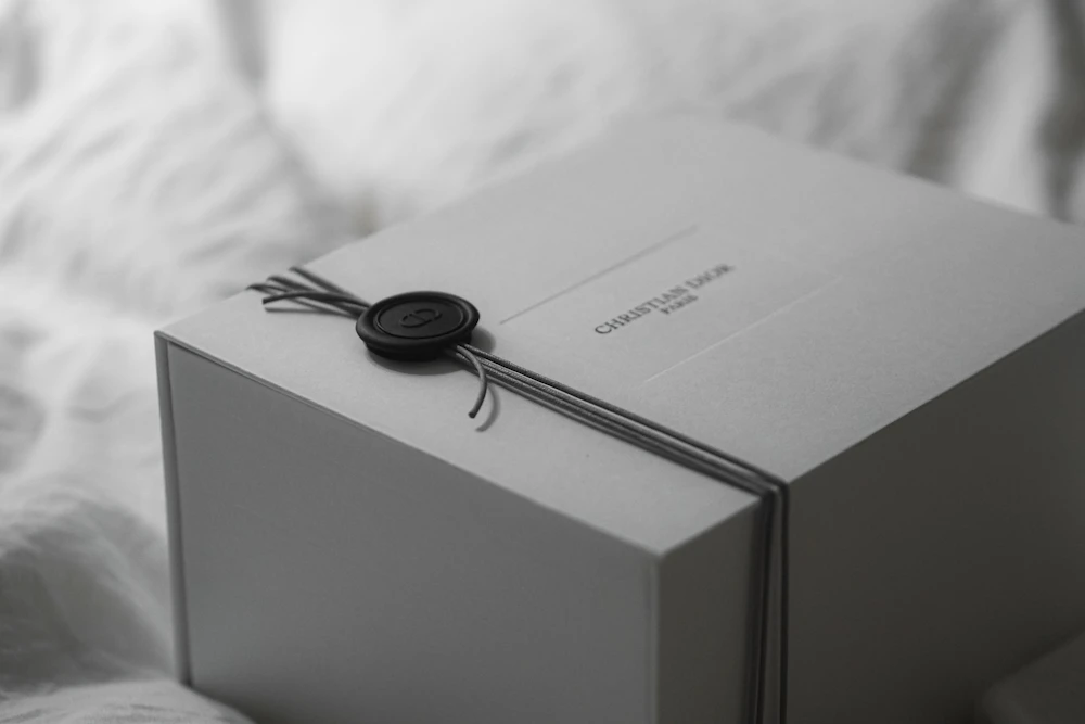 White gift box tied with ribbon and a wax seal, personalized