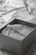 Dior box with dust bag on white fabric