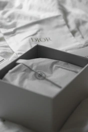 Dior box with dust bag on white fabric