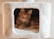 A fluffy orange kitten rests in a white cubby.