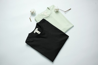 Two t-shirts, black and light green, with cotton stems.