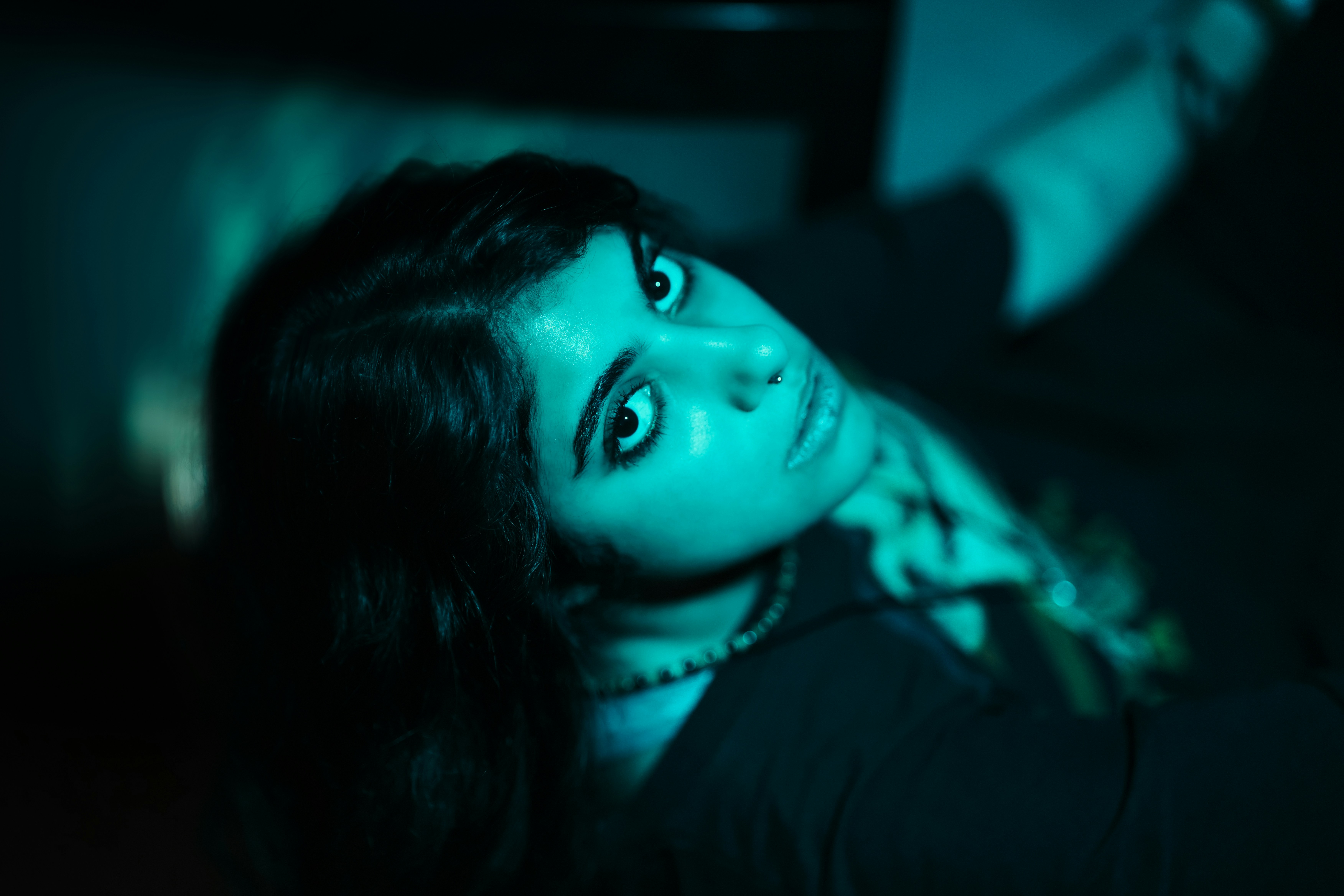 A woman with dark hair looks up intensely