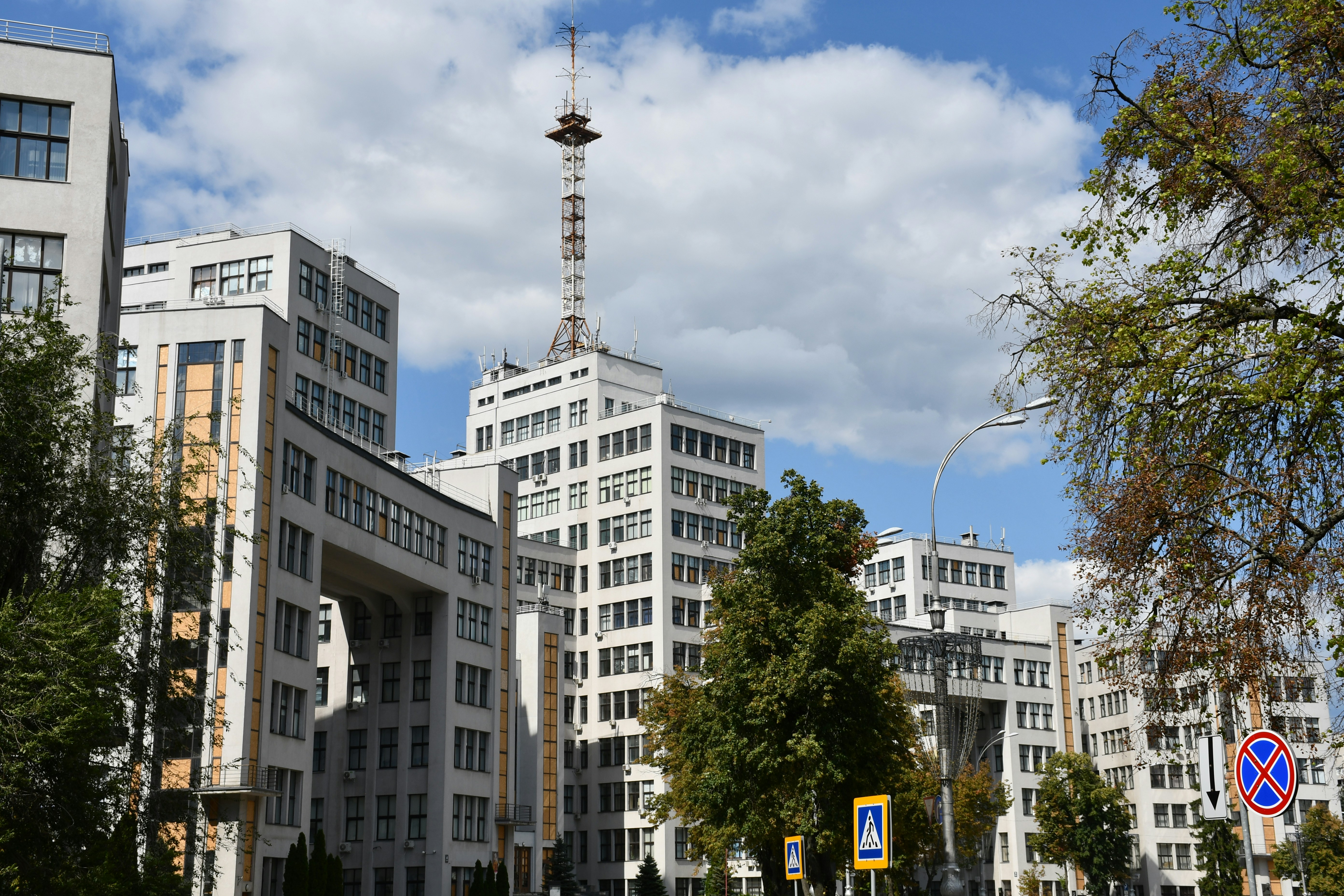 Modern white buildings with a tall antenna tower.
