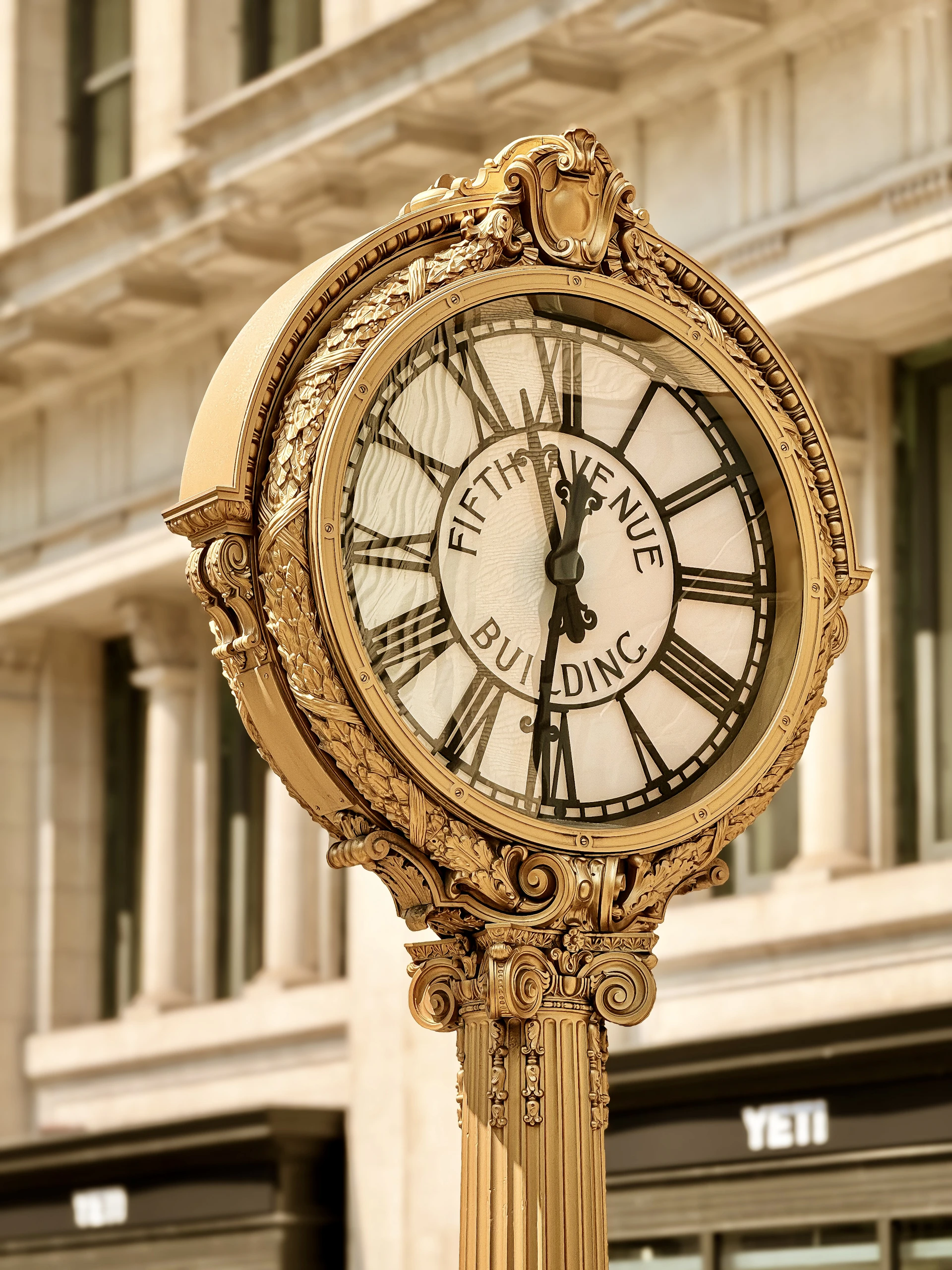 Ornate gold clock on fifth avenue building.