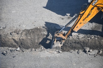 Excavator digging a trench in the road