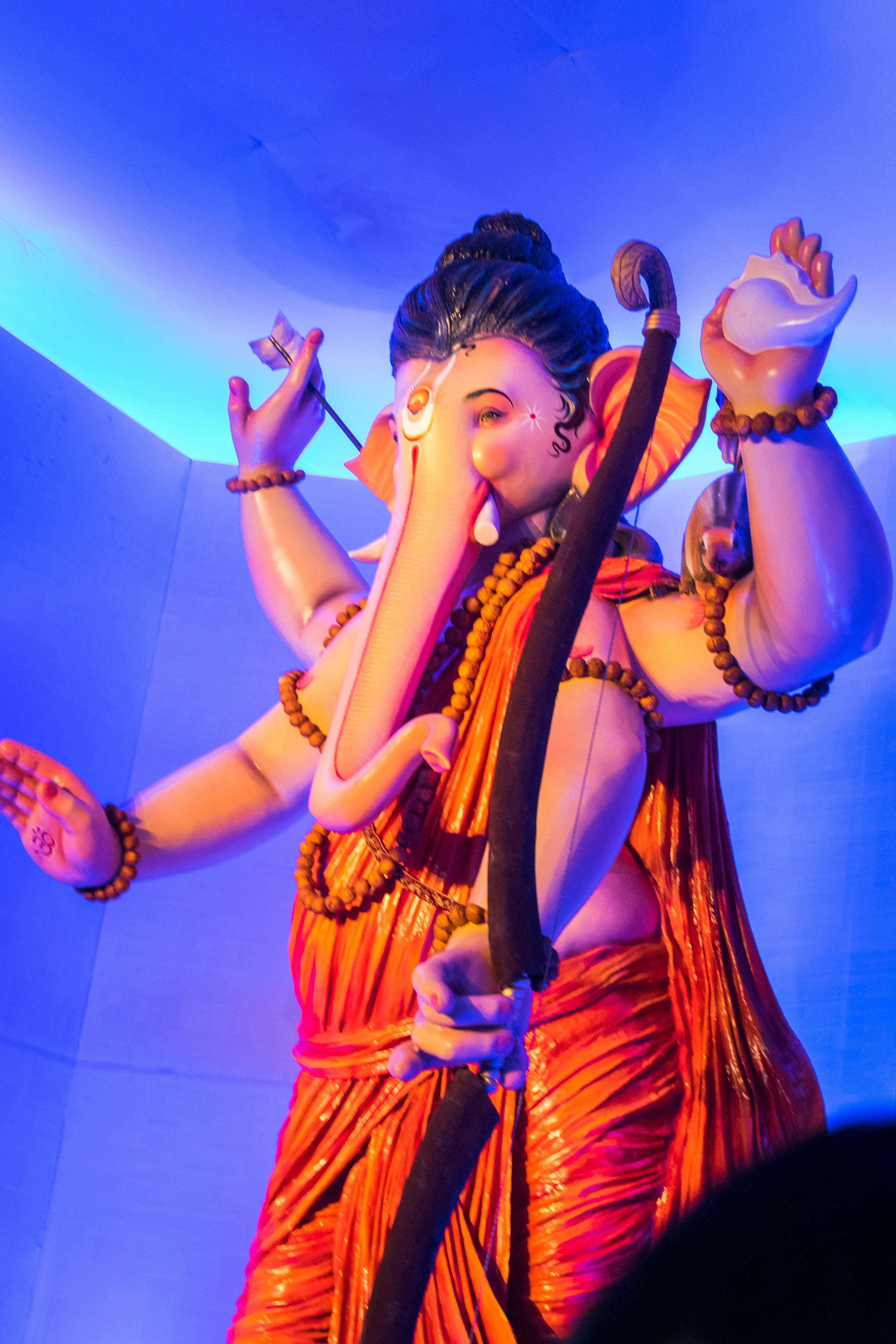 Uma estátua do senhor ganesha segurando um arco e uma concha.