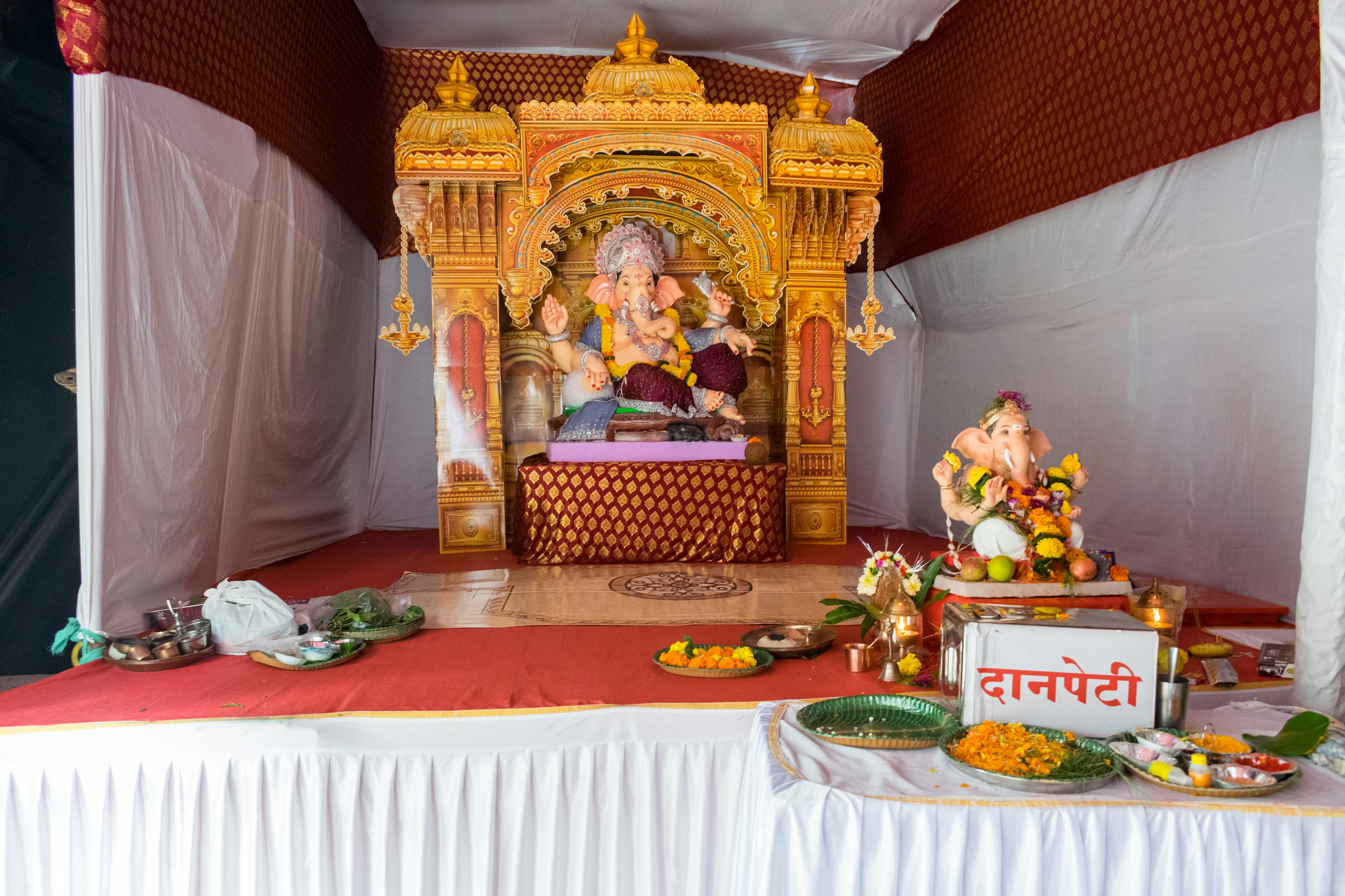 Two ganesha idols displayed on decorated altars.