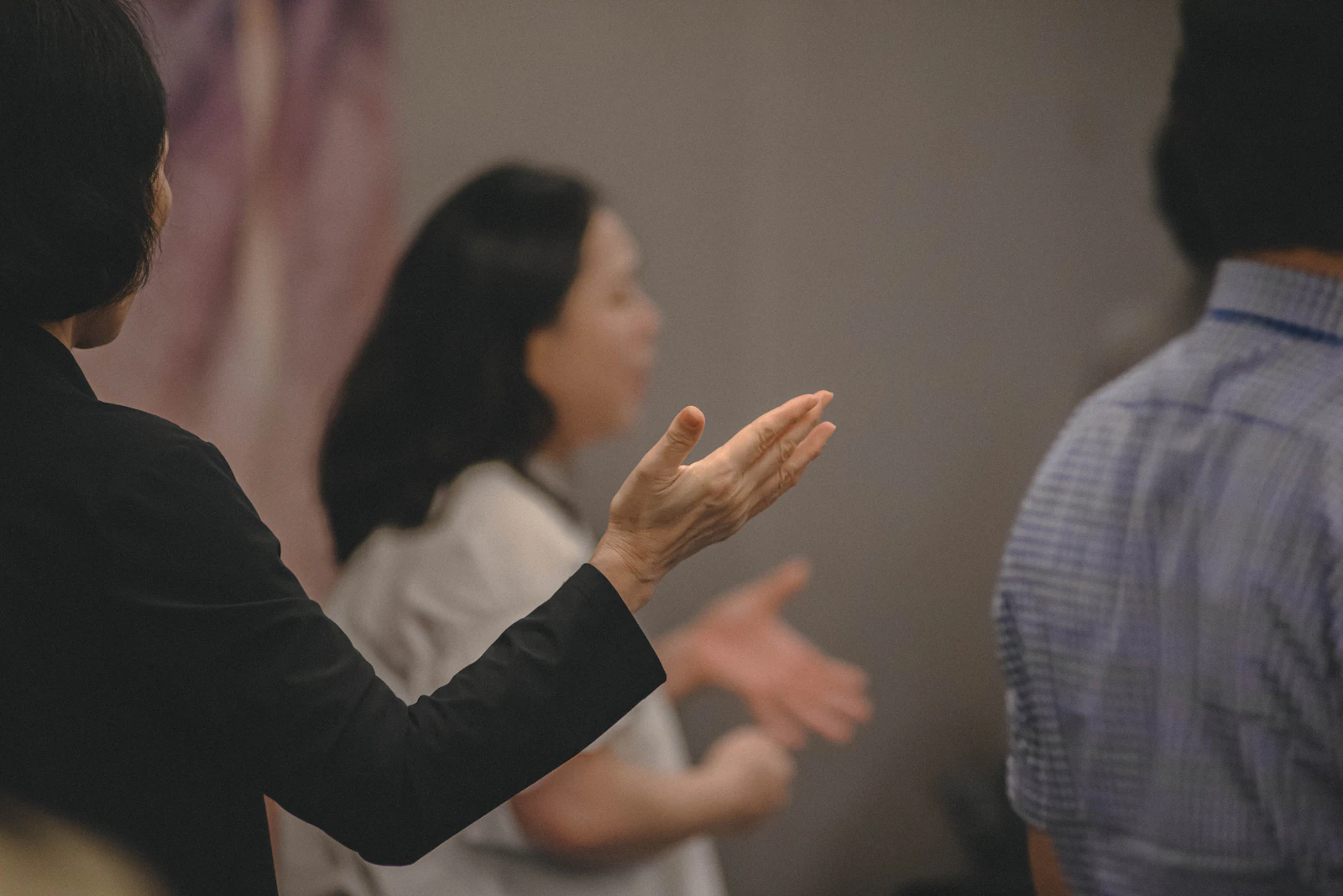 People gesturing in a group discussion, suggesting constructive activism conversations
