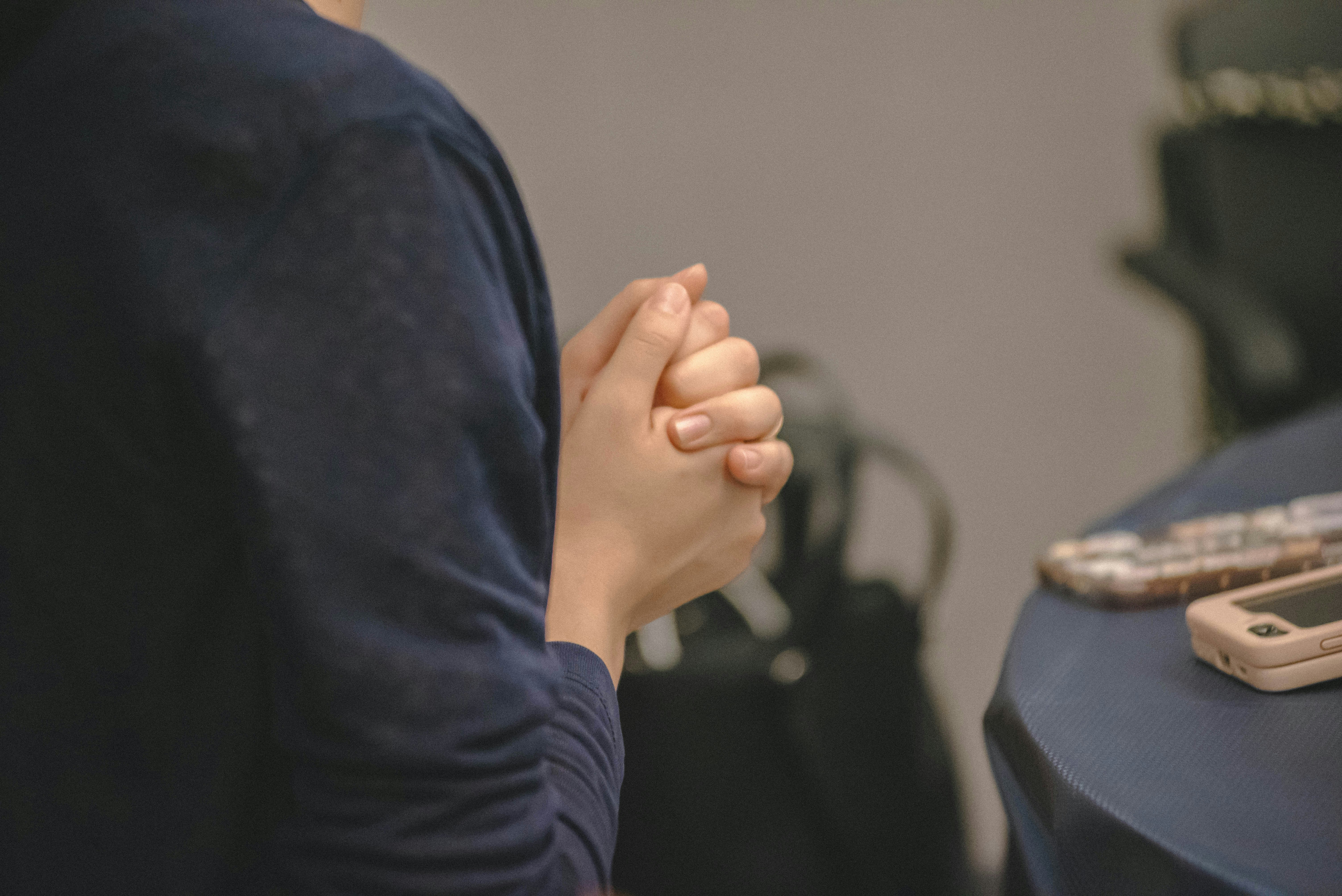 Hands clasped together in prayer or contemplation.