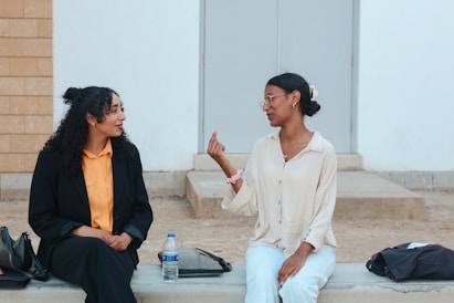 Two women talking while sitting outdoors