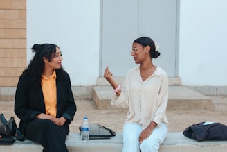 Two women talking while sitting outdoors