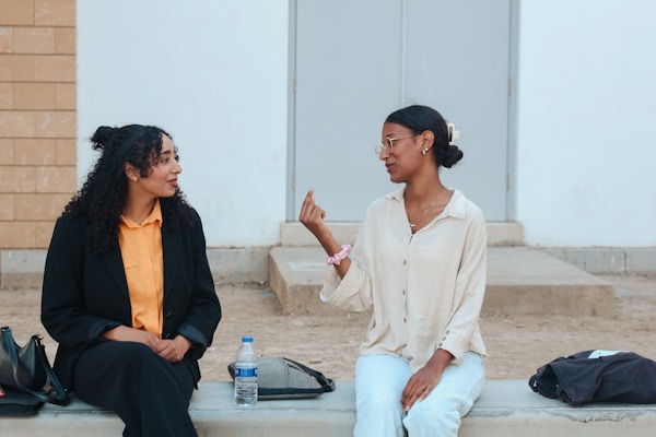 Two women talking while sitting outdoors