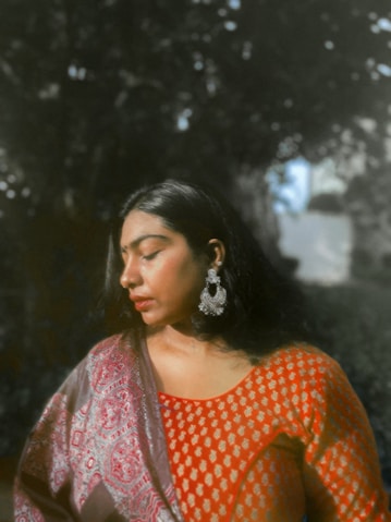 A woman wearing traditional indian clothing and jewelry.